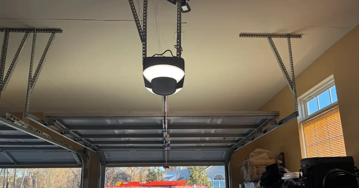 Ceiling-mounted garage door opener with light fixture in a residential garage.